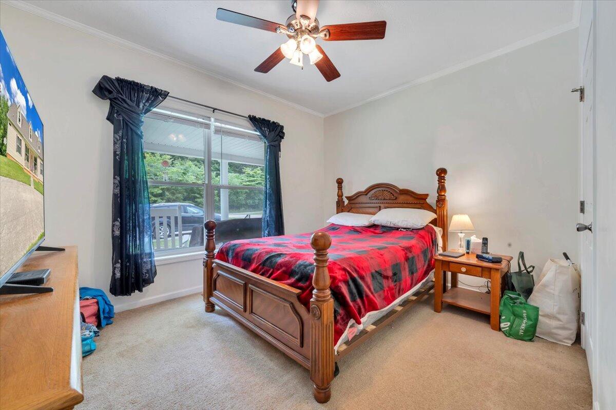60 Tara Drive Ridgeway, VA 24148 - Photo 18 of 93 a spacious bedroom with a bed and a chandelier