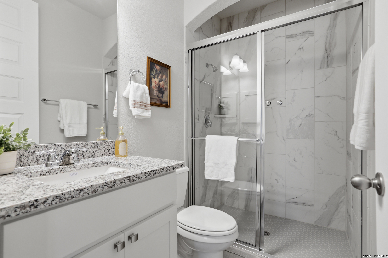 337 Misty Sails Cibolo, TX 78108 - Photo 28 of 50 a bathroom with a granite countertop sink toilet a mirror a shower and a toilet