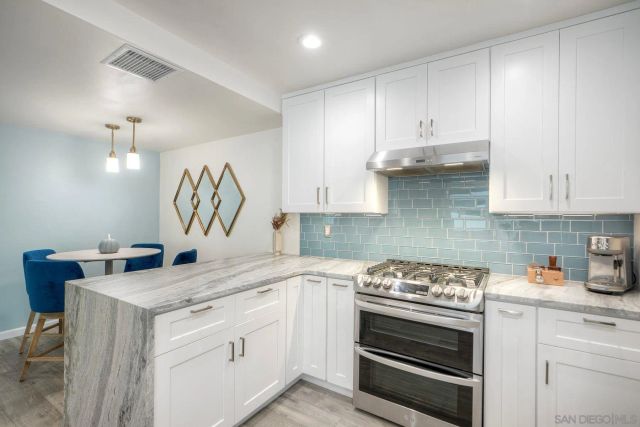 a kitchen with granite countertop white cabinets and white appliances