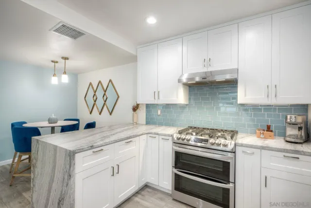 a kitchen with granite countertop white cabinets and white appliances