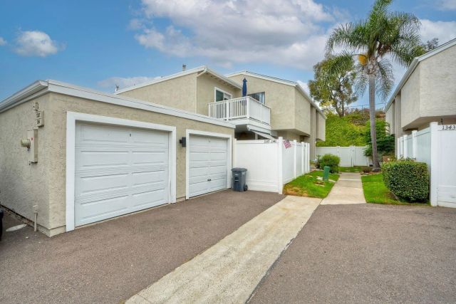 a view of a white house with a yard and garage