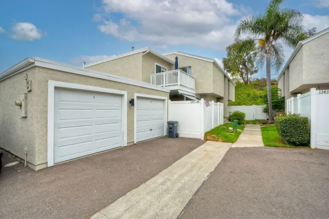 a view of a white house with a yard and garage