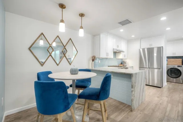 a kitchen with a dining table chairs refrigerator and cabinets