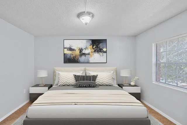 a bedroom with a bed and a painting on the wall