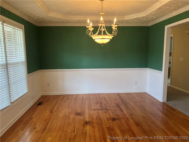 a view of a room with wooden floor and chandelier