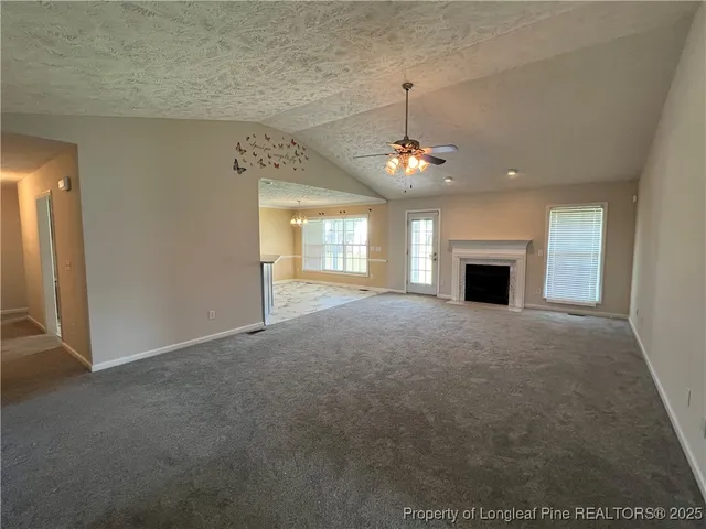 a view of an empty room with window and fire place