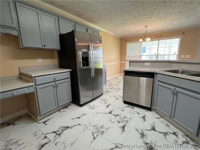 a kitchen with granite countertop a refrigerator sink and cabinets