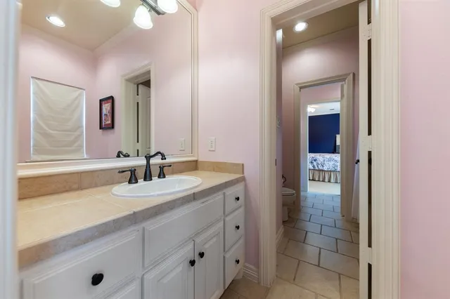 a bathroom with a granite countertop sink and a mirror