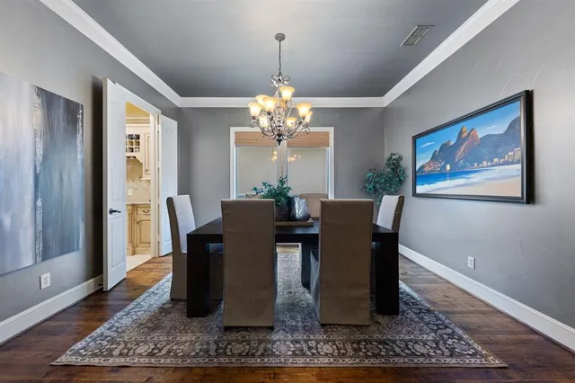 a view of a dining room with furniture a chandelier and wooden floor