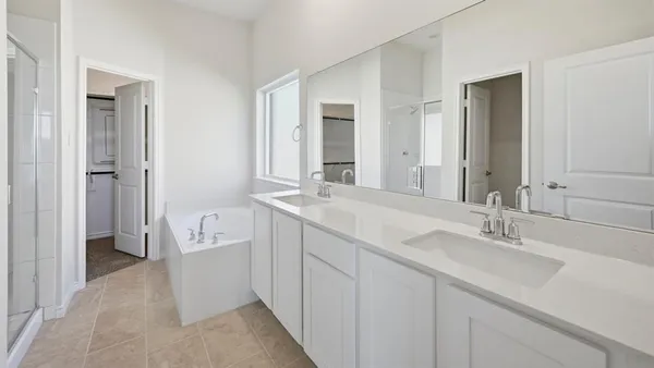 a spacious bathroom with a double vanity sink a mirror and a bathtub