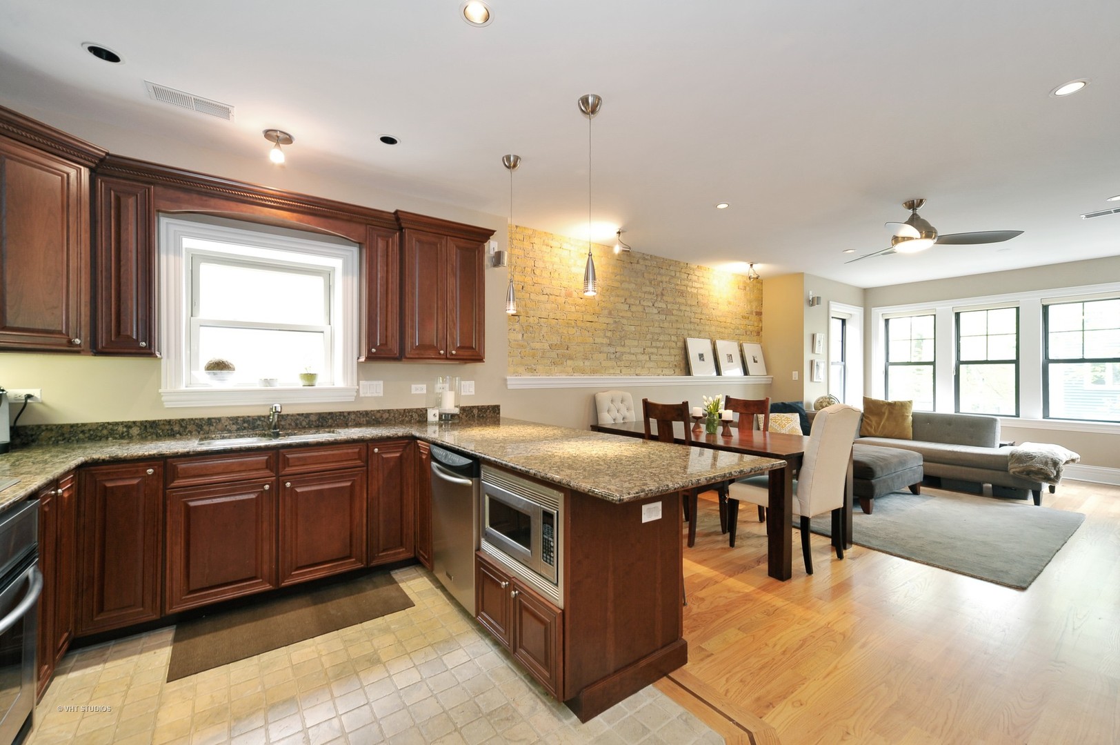 3933 North Marshfield Avenue, Unit 2S Chicago, IL 60613 - Photo 7 of 17 a large kitchen with stainless steel appliances granite countertop a large counter top a stove a sink a dining table and chairs