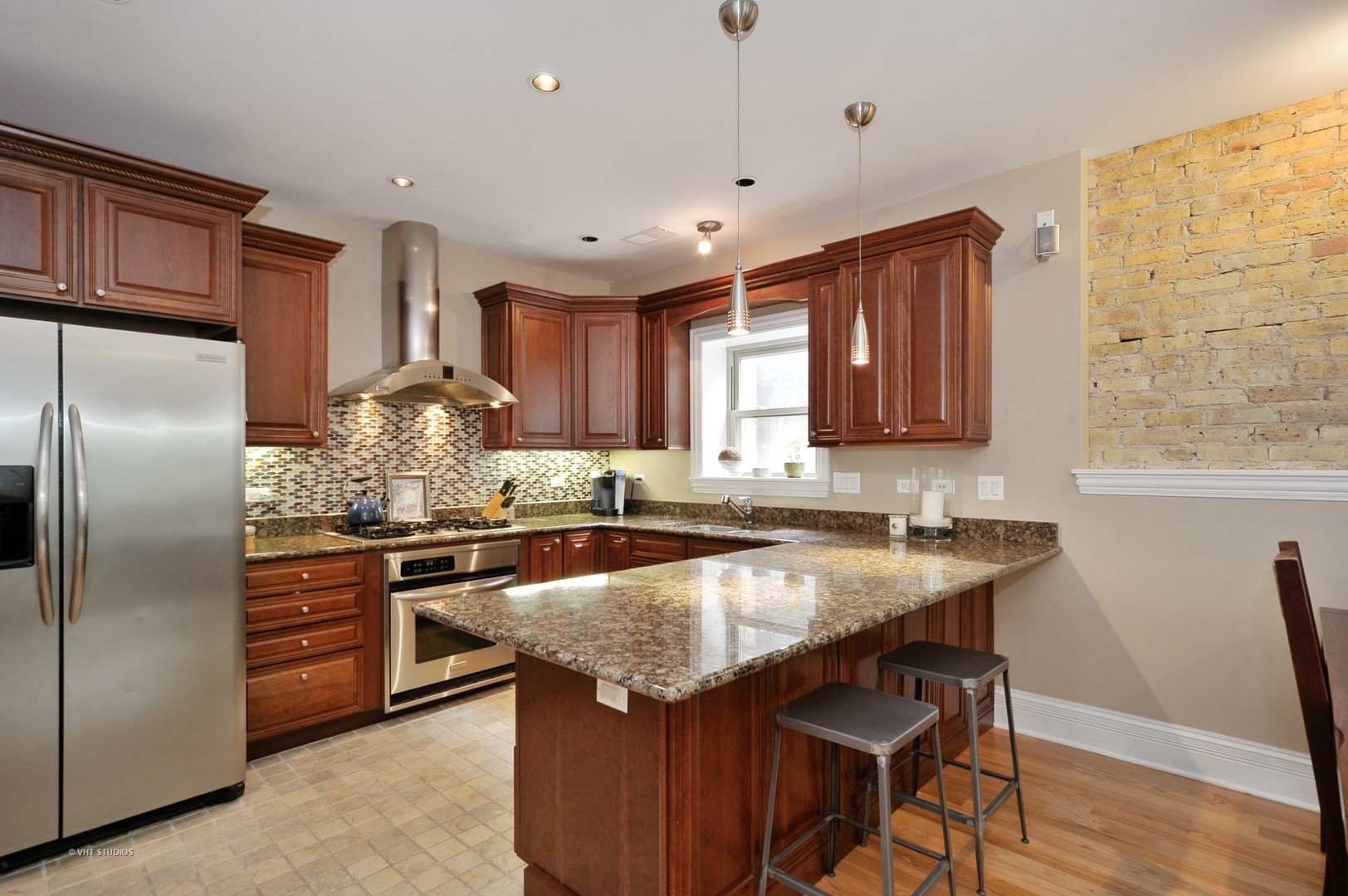 3933 North Marshfield Avenue, Unit 2S Chicago, IL 60613 - Photo 9 of 17 a kitchen with stainless steel appliances granite countertop a table chairs sink refrigerator and microwave