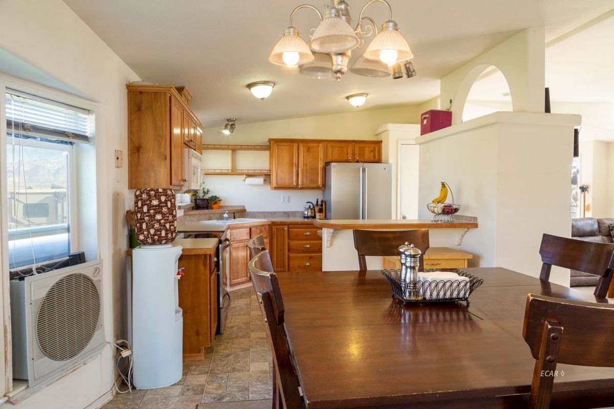 426 Spring Valley Parkway Spring Creek, NV 89815 - Photo 6 of 16 a view of a dining room with furniture a chandelier and wooden floor