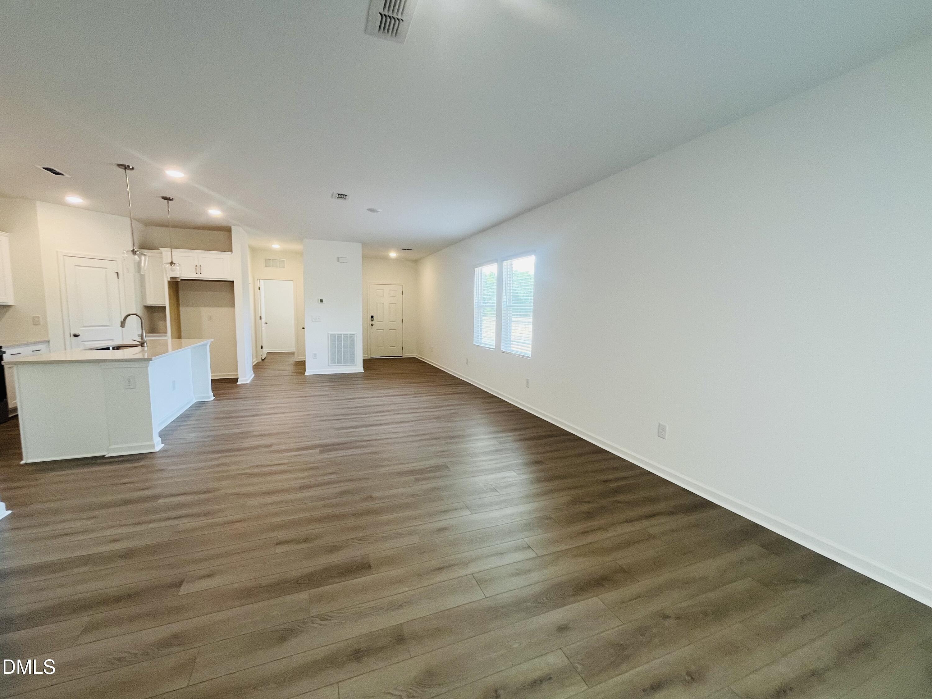 11487 Salers Loop Middlesex, NC 27557 - Photo 17 of 31 a view of an empty room with wooden floor and a kitchen