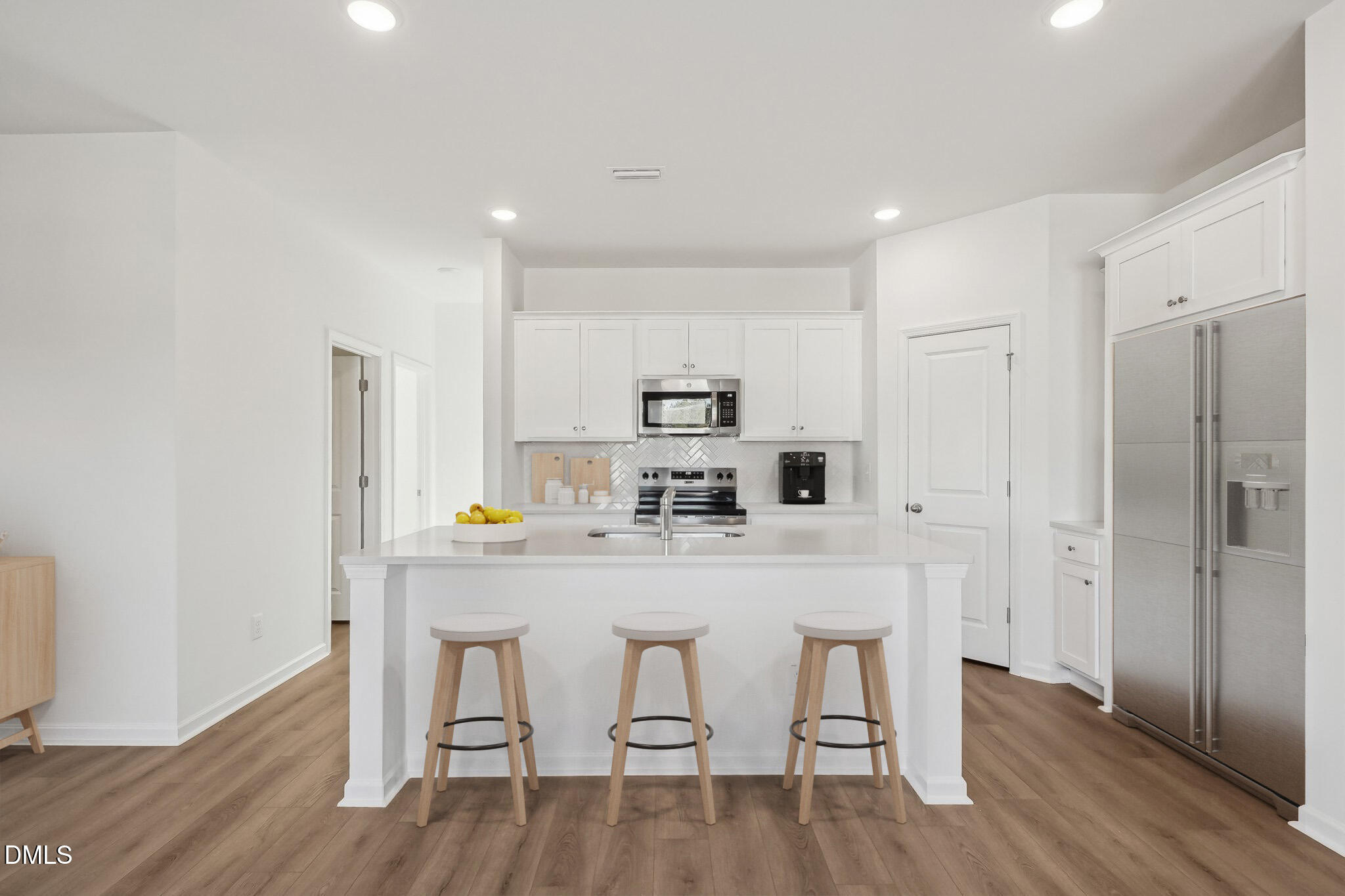 11487 Salers Loop Middlesex, NC 27557 - Photo 4 of 31 a kitchen with stainless steel appliances a dining table chairs refrigerator and sink