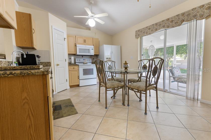 11251 Pickford Street Spring Hill, FL 34609 - Photo 6 of 29 a view of a dining room with furniture a chandelier and kitchen view