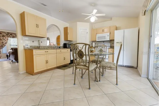 a kitchen with stainless steel appliances granite countertop a stove a sink a dining table and chairs