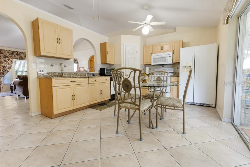 11251 Pickford Street Spring Hill, FL 34609 - Photo 7 of 29 a kitchen with stainless steel appliances granite countertop a stove a sink a dining table and chairs