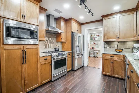 a kitchen with stainless steel appliances granite countertop a stove a refrigerator and a microwave