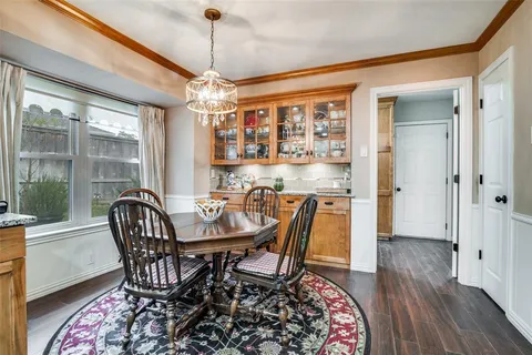a dining room with furniture a chandelier and wooden floor