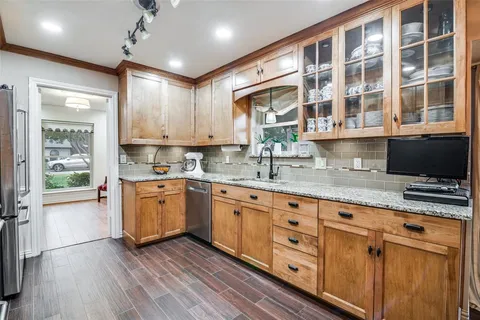 a kitchen with stainless steel appliances granite countertop a stove a sink and a granite counter tops with wooden floors