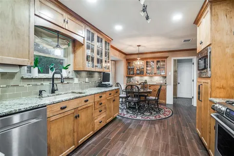 a kitchen with stainless steel appliances granite countertop a stove a sink and a refrigerator