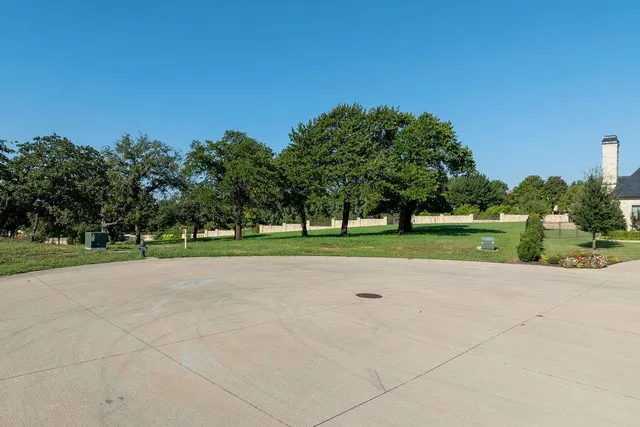 a front view of a house with a yard and fountain in middle