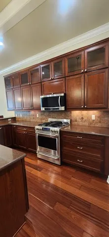 a kitchen with wooden cabinets and stainless steel appliances
