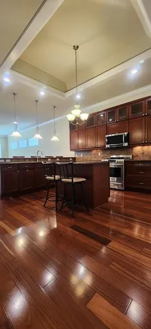 a kitchen with stainless steel appliances kitchen island granite countertop a stove a sink and a microwave
