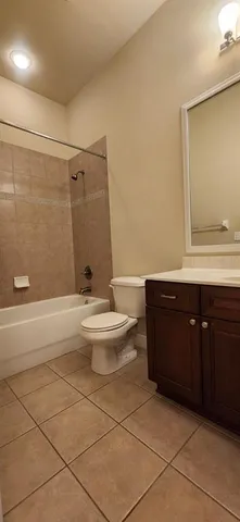a bathroom with a granite countertop sink a toilet a mirror and shower