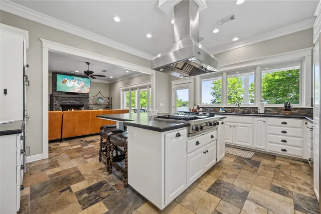 a kitchen with granite countertop lots of white cabinets and black appliances