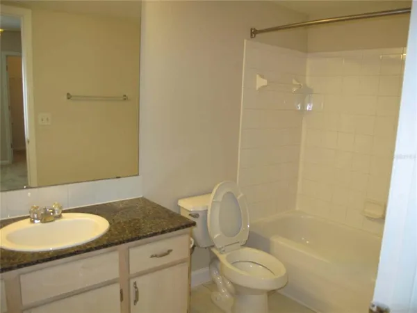 a bathroom with a granite countertop sink toilet and a mirror