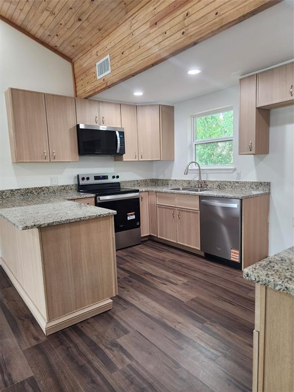 1133 Highway 2861 Comanche, TX 76442 - Photo 7 of 15 a kitchen with stainless steel appliances granite countertop wooden cabinets a sink a stove a microwave and cabinetry