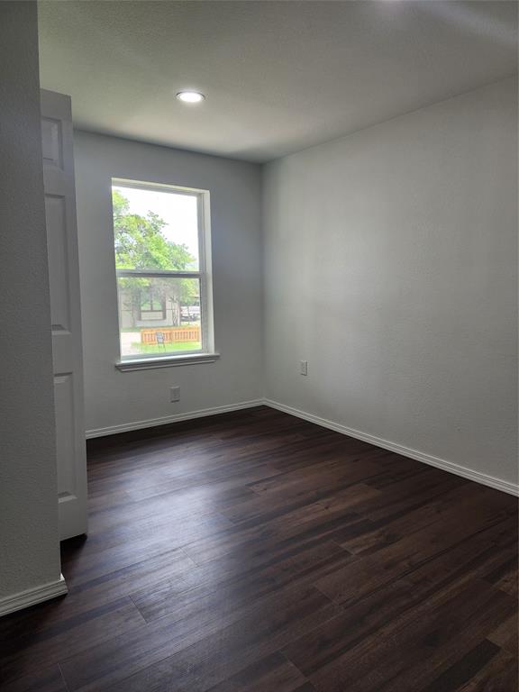 1133 Highway 2861 Comanche, TX 76442 - Photo 10 of 15 an empty room with wooden floor and windows