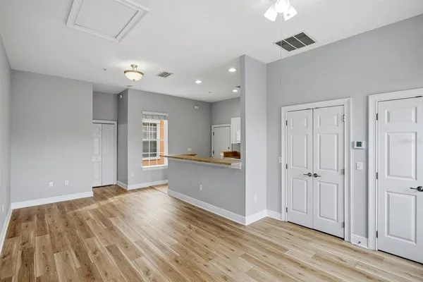 an empty room with wooden floor and windows