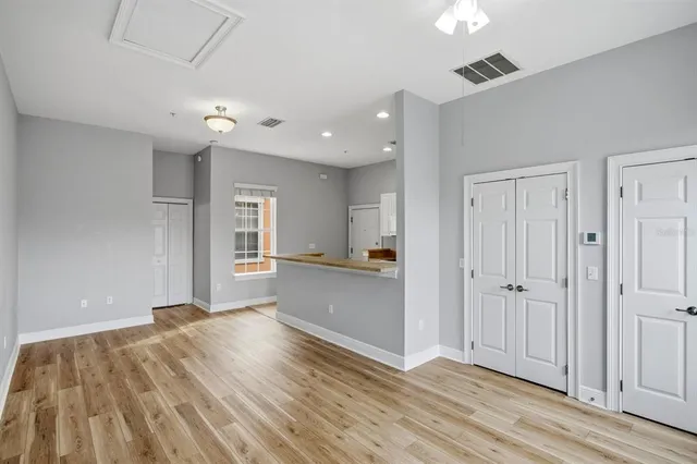 an empty room with wooden floor and windows