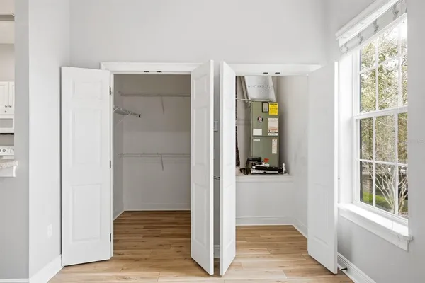a view of a hallway with wooden floor and windows in a room