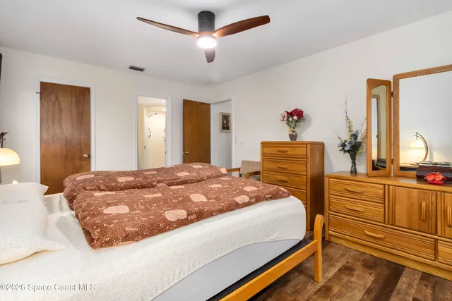 a bedroom with a bed and dresser with mirror