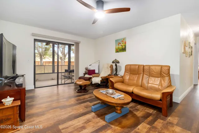 a living room with furniture a flat screen tv and a large window