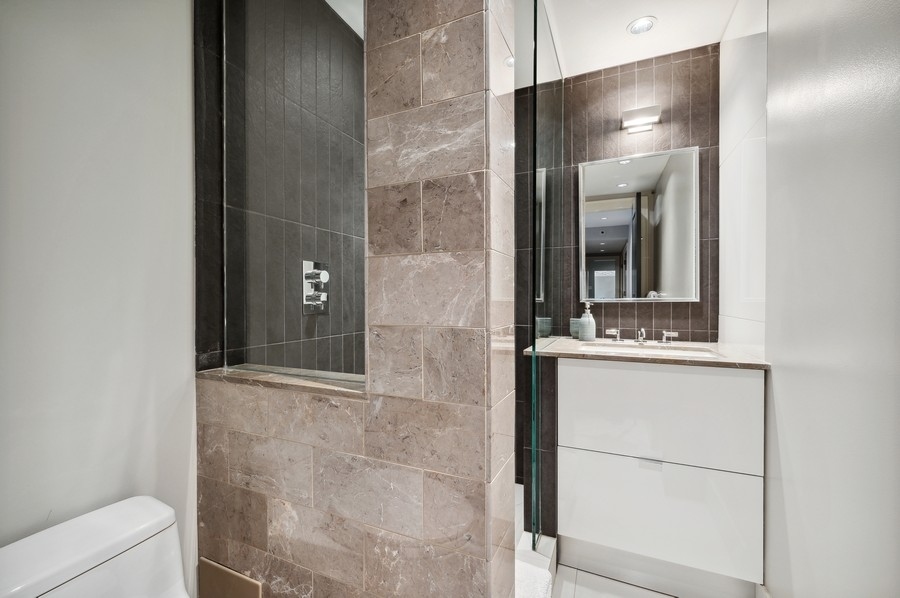 20 East Cedar Street, Unit 4D Chicago, IL 60611 - Photo 19 of 29 a bathroom with a granite countertop shower a mirror and vanity