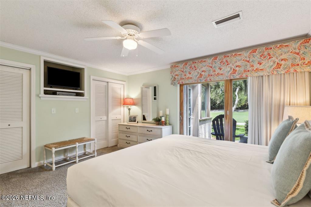 3328 Sea Marsh Road Fernandina Beach, FL 32034 - Photo 24 of 43 a bedroom with a large bed and a flat tv screen