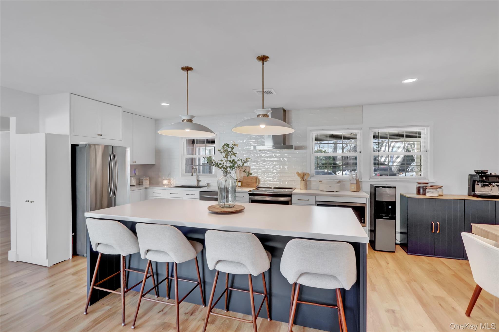 15 Whitmore Lane Coram, NY 11727 - Photo 5 of 10 a kitchen with stainless steel appliances a dining table chairs and wooden floor