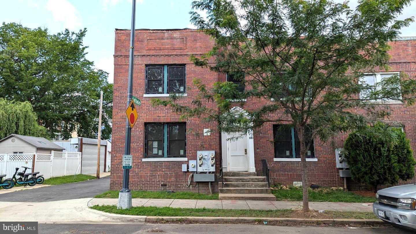 a front view of a house with a tree