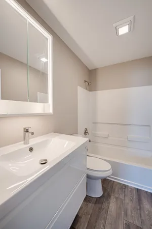 a bathroom with a sink a toilet and shower