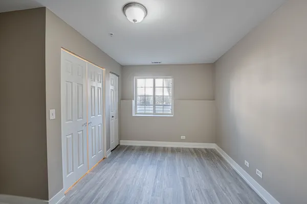 a view of a room with wooden floor and windows