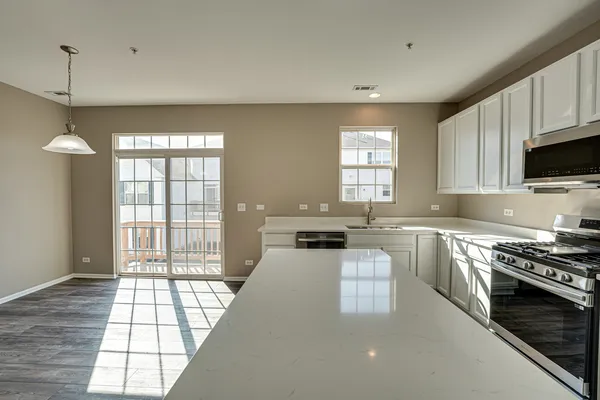 a kitchen with stainless steel appliances granite countertop a stove a sink and a microwave