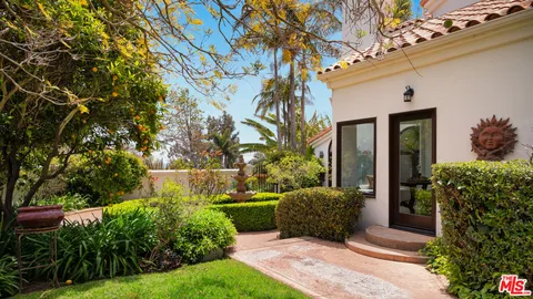 a view of a patio with table and chairs potted plants and large tree