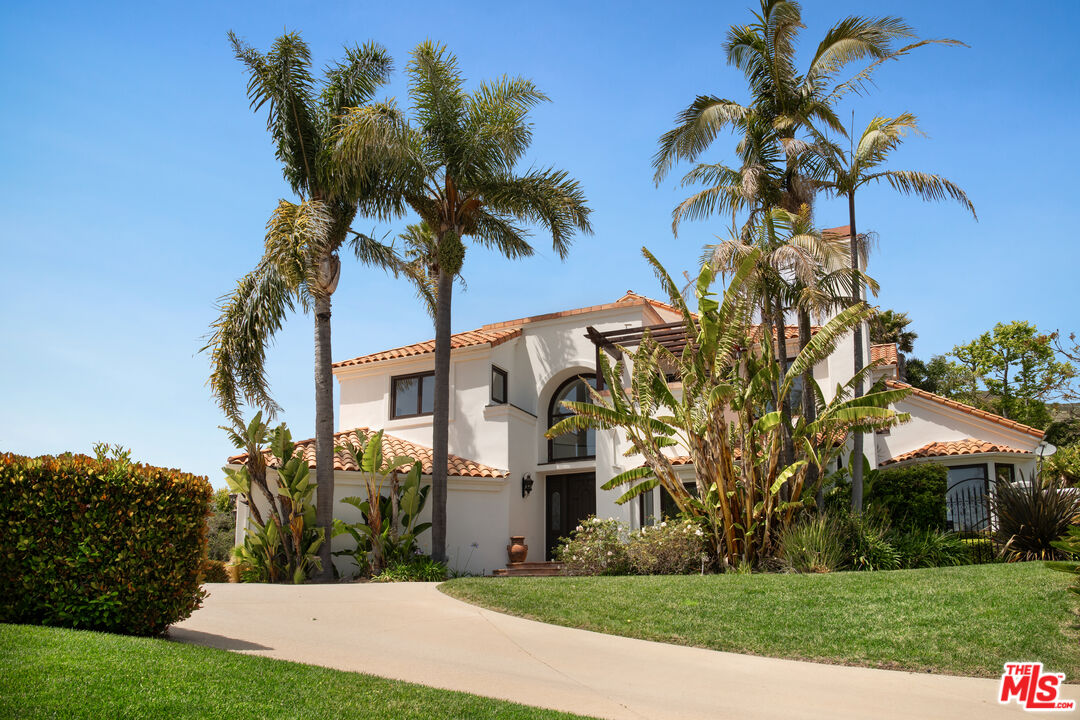 29675 Harvester Road Malibu, CA 90265 - Photo 5 of 36 a view of a white house with a big yard and palm trees
