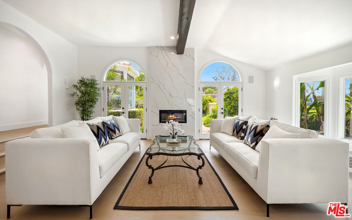29675 Harvester Road Malibu, CA 90265 - Photo 8 of 36 a living room with furniture fireplace and a large window