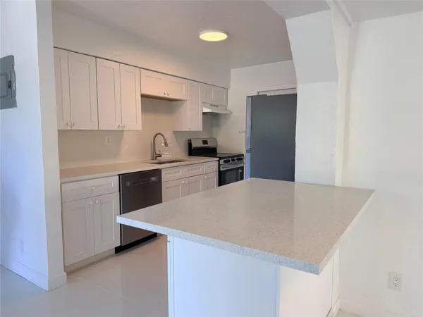 a kitchen with cabinets and white stainless steel appliances